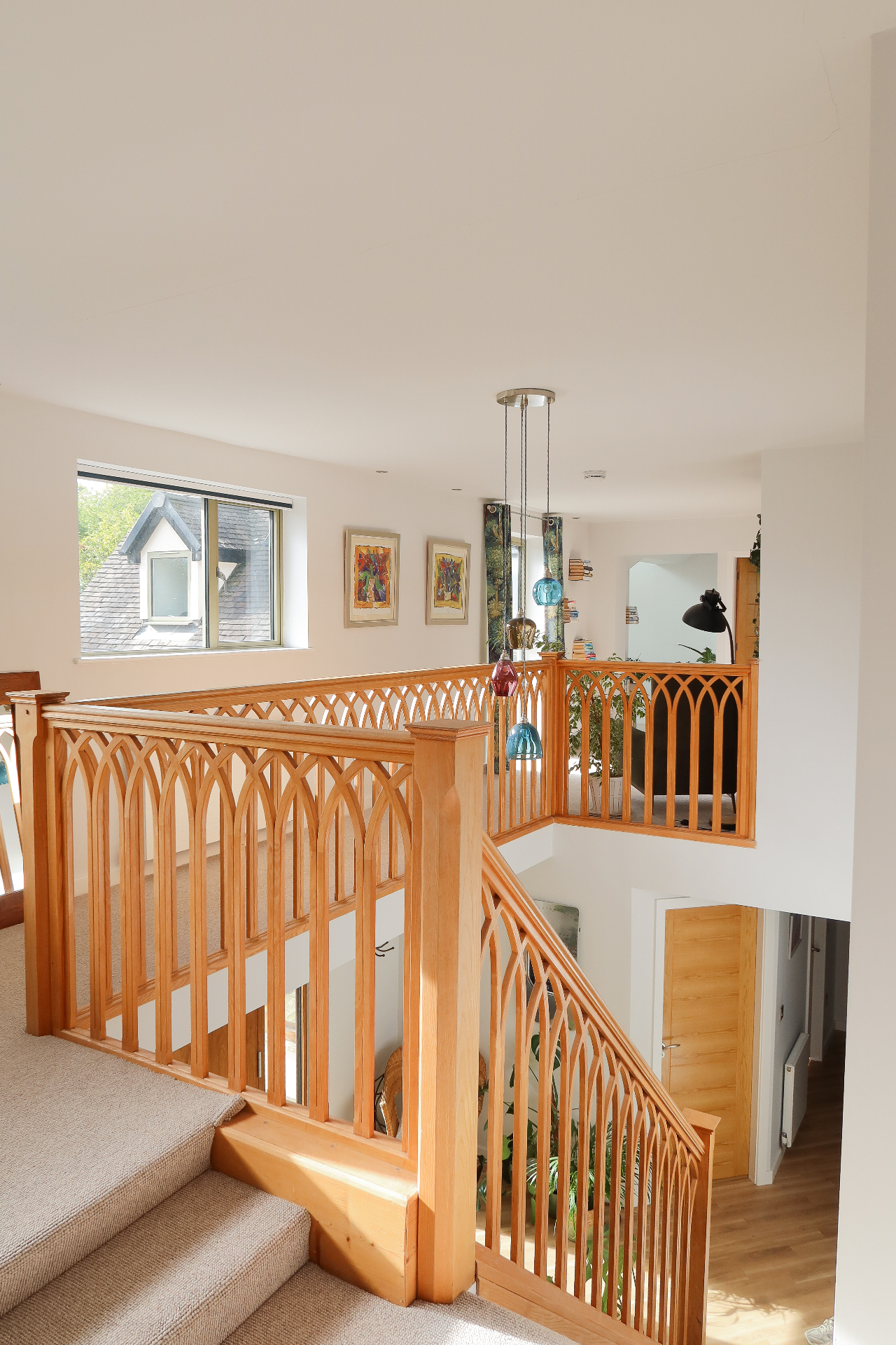 Bespoke oak staircase and first floor gallery with arched timber balustrade detail