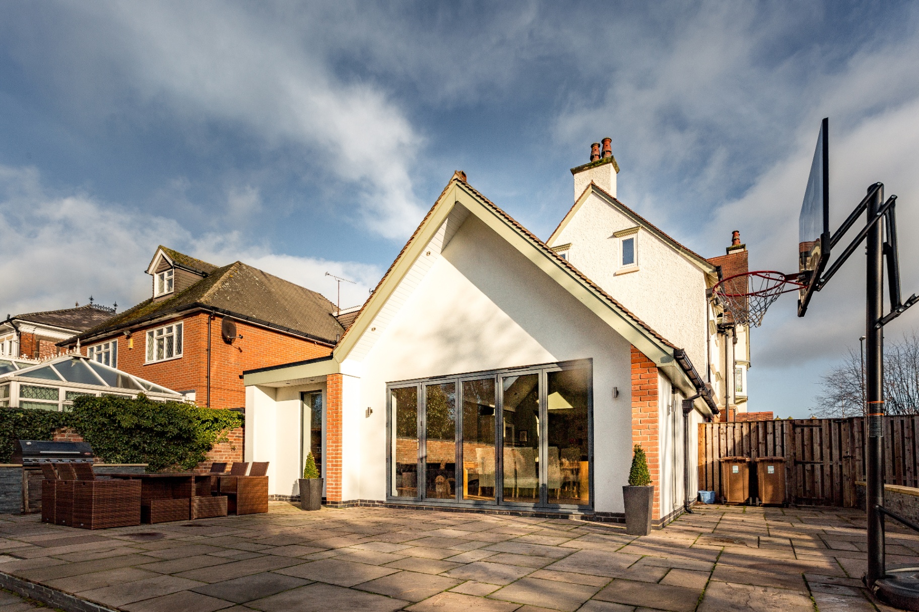 Contemporary rendered rear extension with aluminium bifold doors onto the patio