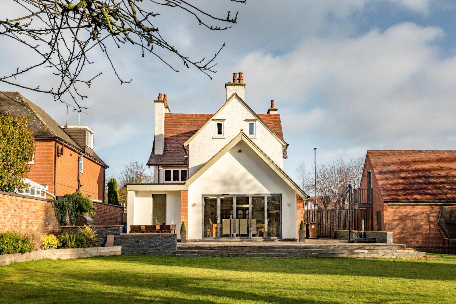 Rear bifold-door extension to an Edwardian house with contemporary rendered gable