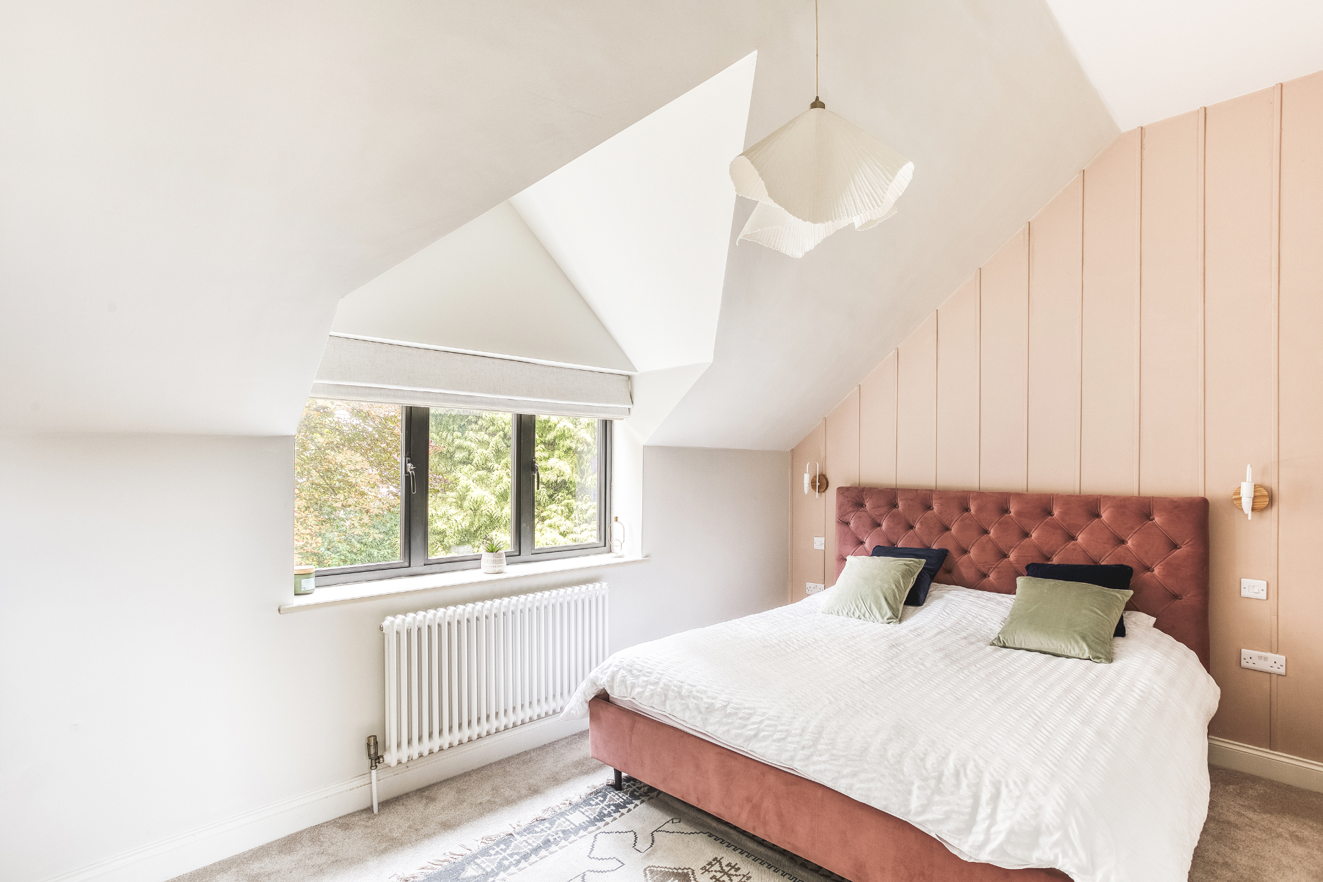 Loft bedroom with vaulted ceiling, upholstered headboard and soft natural light