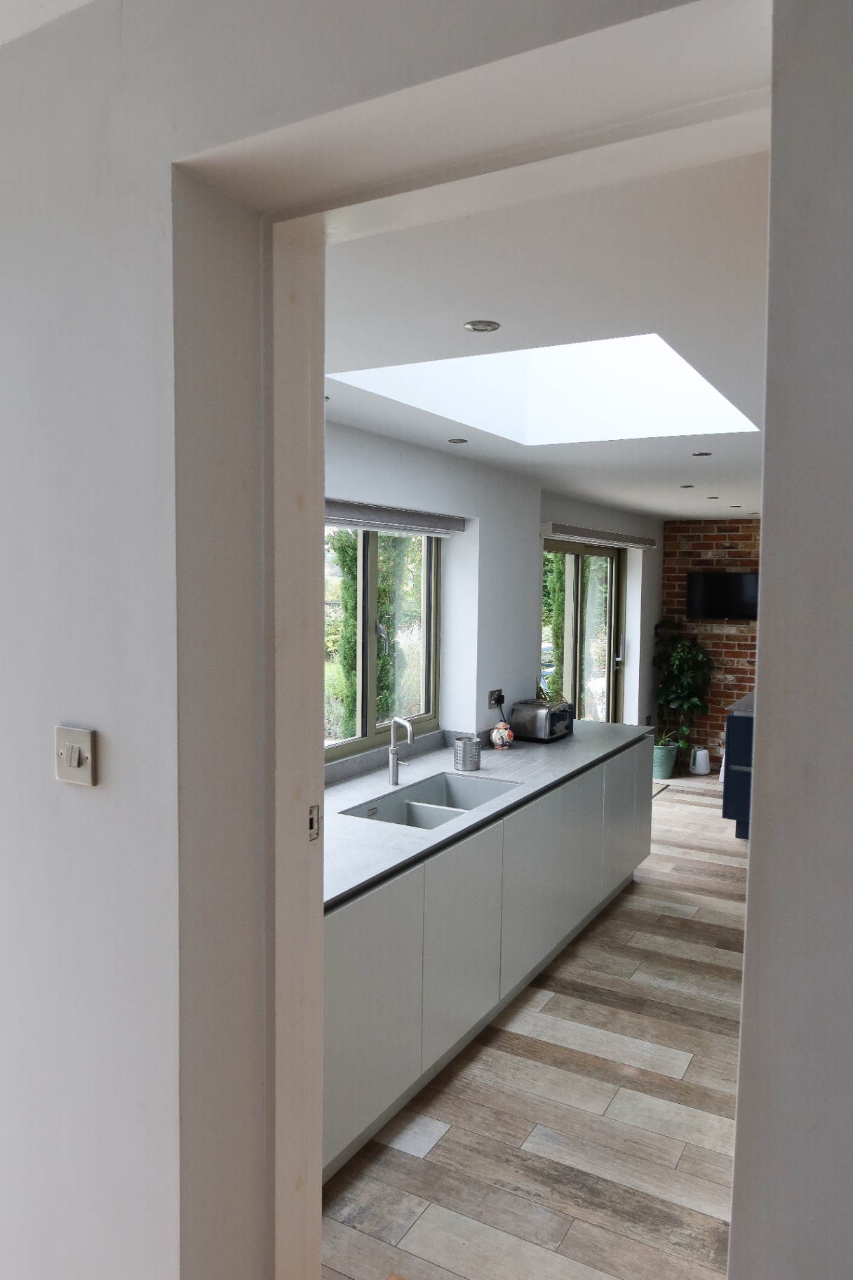 Contemporary handleless kitchen with island, skylight and views out to the garden
