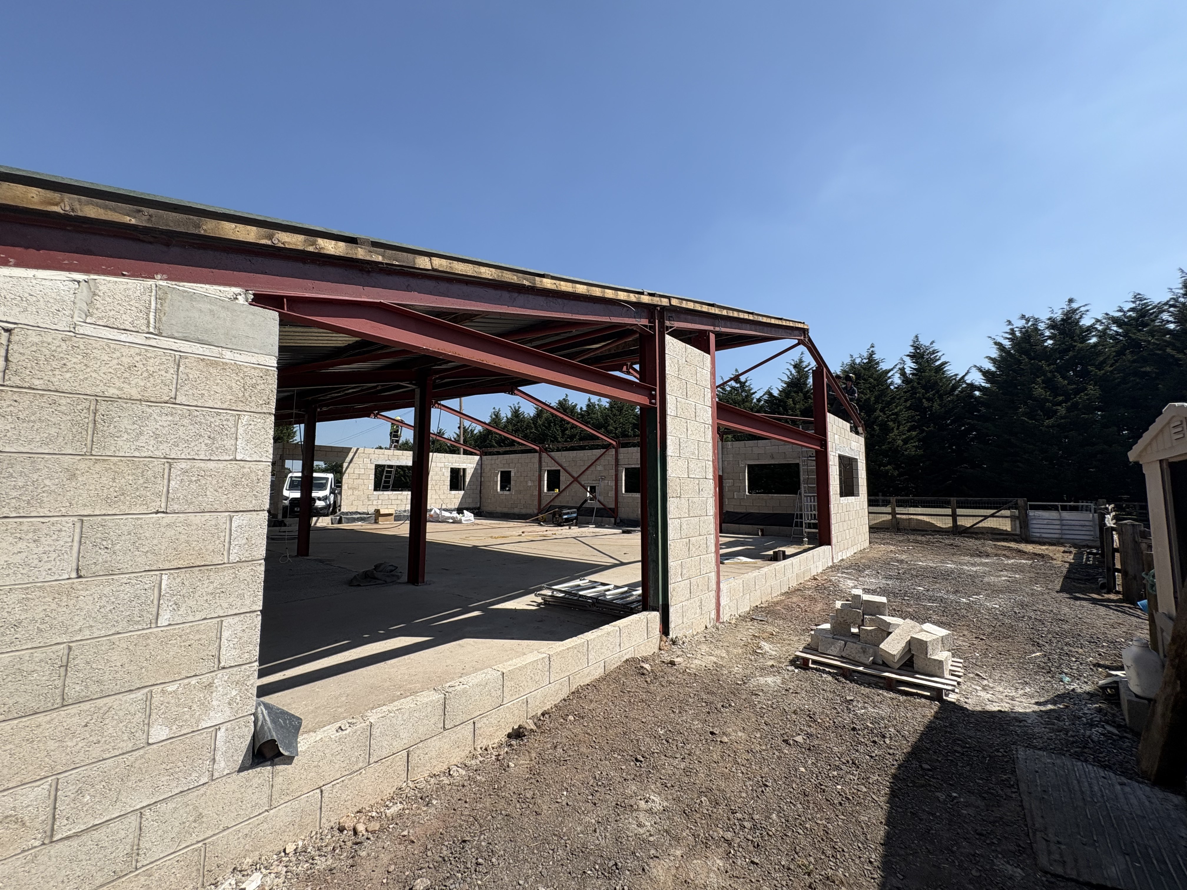 Interior view of the Heronfield Farm barn mid-conversion with punched window openings framing the rural landscape