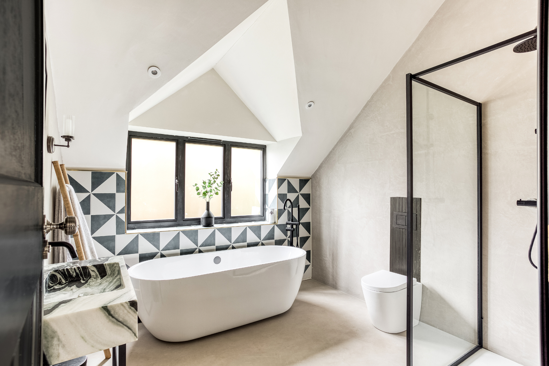 Contemporary loft bathroom with freestanding bath, geometric tiling and walk-in shower