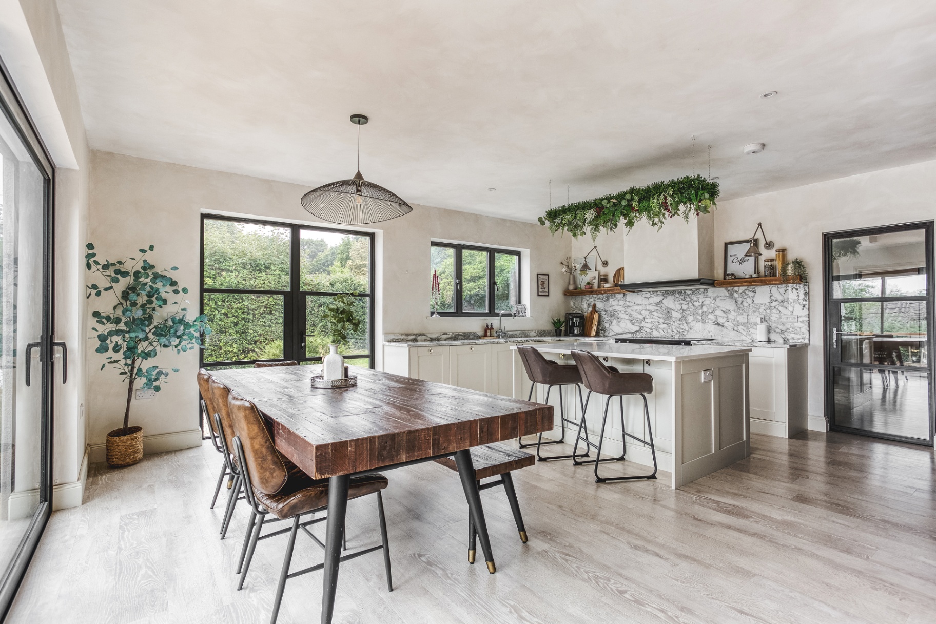 Open-plan kitchen and dining area with marble splashback, island and garden views